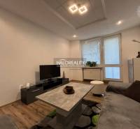 Living room in a two-room apartment with a wooden decor floor and a television.