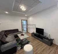 Living room with a sofa set, television, and wooden decor flooring in a two-room apartment.