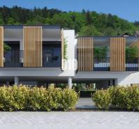 A modern building with wooden elements on Dolná Street in Žilina, surrounded by greenery.