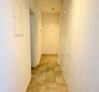 Hallway in a 2-room apartment with white walls and tiled floor.