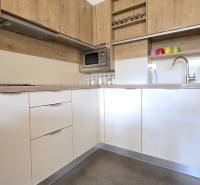 A kitchen in a 3-room apartment with a wooden decor floor and a built-in oven.