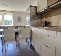Interior of a 3-room apartment with a kitchen and living room, floor with wooden decor.