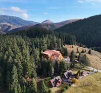 Forest landscape with buildings, Donovaly, Donovaly spiežovecc, surrounded by mountains and forests.