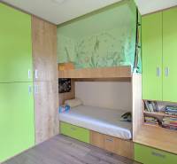 A children's room with a bunk bed, green cabinets, and a wood-patterned floor in a three-room apartment.