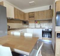 A kitchen in a 3-room apartment with a wooden decor floor and high-quality kitchen equipment.