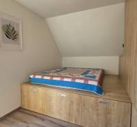 A room in a 3-room apartment with storage space and a blanket on the bed.