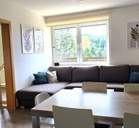 Living room with a sofa, decorations, and large windows in a three-room apartment.