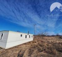 Mobile home on agricultural and forest land in Radvaň nad Dunajom under the blue sky.