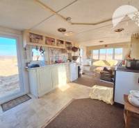Interior with a kitchen, stove, and view of agricultural and forest land.