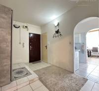 Interior of a 1-room apartment with white tiles and a carpet at the entrance.