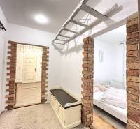 A carpet and brick walls in the hallway of a 3-room apartment.