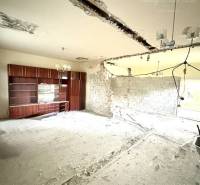 The interior of a family house with an exposed ceiling and construction materials on the floor.