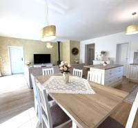 A dining room in a family house with a wood-patterned floor, light walls, pendant lights.