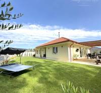 A garden at a family house in Dunajská Streda with a lounger and a terrace under the blue sky.