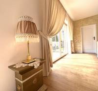 Interior of a family house with a lamp, curtains, and a wooden decor floor.
