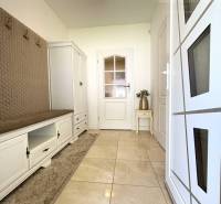 Entrance hall of a family house with white storage furniture and a coat rack.