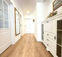 Hallway in a family house with wood-patterned flooring, decorations, and lighting.
