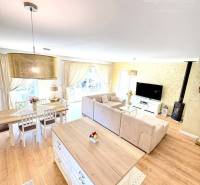 Interior of a family house with a wooden decor floor, dining table, and sofa.