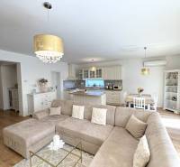 Living room in a family house with a large couch, wooden decor, and a golden chandelier.