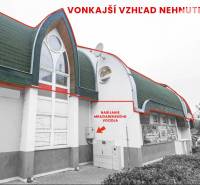 Exterior of commercial premises in Komárno with an interesting roof and modern windows.