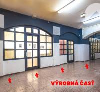 Interior of commercial spaces with glass doors and illuminated ceiling lighting.