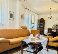 Living room in a family house with yellow sofas and a chandelier, floor with wood decor.
