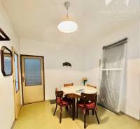 Dining room in a 2-room apartment with a simple wooden table and chairs.