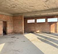 An unfinished building with bare walls and ceiling, view into the interior of a family house.