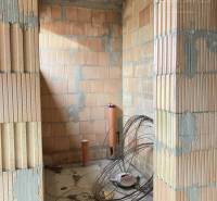 Unfurnished interior of a family house with brick walls and construction materials.