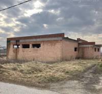 An unfinished family house in Zlatná na Ostrove on an open plot under a cloudy sky.