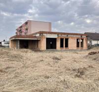 Construction of a family house in Zlatná na Ostrove, grassy plot, sky with clouds.