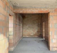 The interior construction of a family house with bare brick walls.