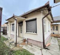 A family house in the town of Strekov with a stone pathway and a plastered facade in the background.