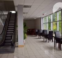 Commercial space with an escalator and tables, ideal for offices or a relaxation zone.