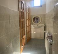 Bathroom with tiles, sink, and wooden door in the area of Warehouses and halls.
