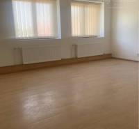 Interior with light walls, wood-patterned flooring, blinds on the windows.