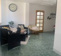 Interior with a table, chairs, clock, and tiled floor, warehouses and halls.