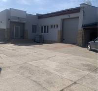 Warehouses and halls on Hlavná Street in Chotín, concrete area and garage doors.