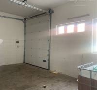 Interior of warehouses and halls with a garage door and lights on the wall.