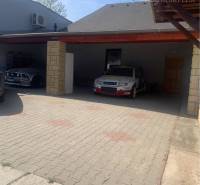 Parking lot on Main Street in Chotín with a car shelter near the warehouse halls.