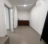 Interior of commercial spaces with tiled floors and white walls.