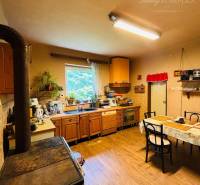 Kitchen with wooden floor, tiles, and dining table. Property - living.