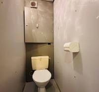 A bathroom in a 3-room apartment, simple interior with gray walls and floor.