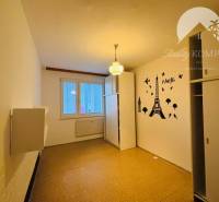 A room in a 3-room apartment with a sticker of the Eiffel Tower on the wall.