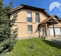 A family house in Dunajská Streda with a garage and a front garden, surrounded by greenery.