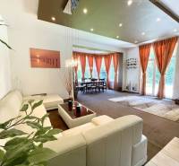 Living room in a family house with a white sofa and large windows.