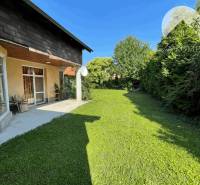 A family house in Dunajská Streda with a lawn and a terrace surrounded by trees.
