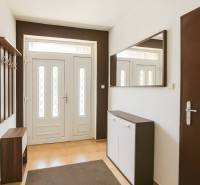 The entrance hall in the family house with white doors and orange tiles.