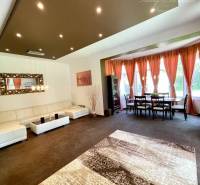 Living room in a family house with a white sofa, curtains, and a coffee table.