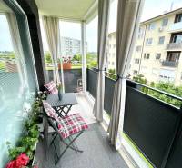 The balcony of a 2-room apartment in Dunajská Streda with garden furniture and flowers.